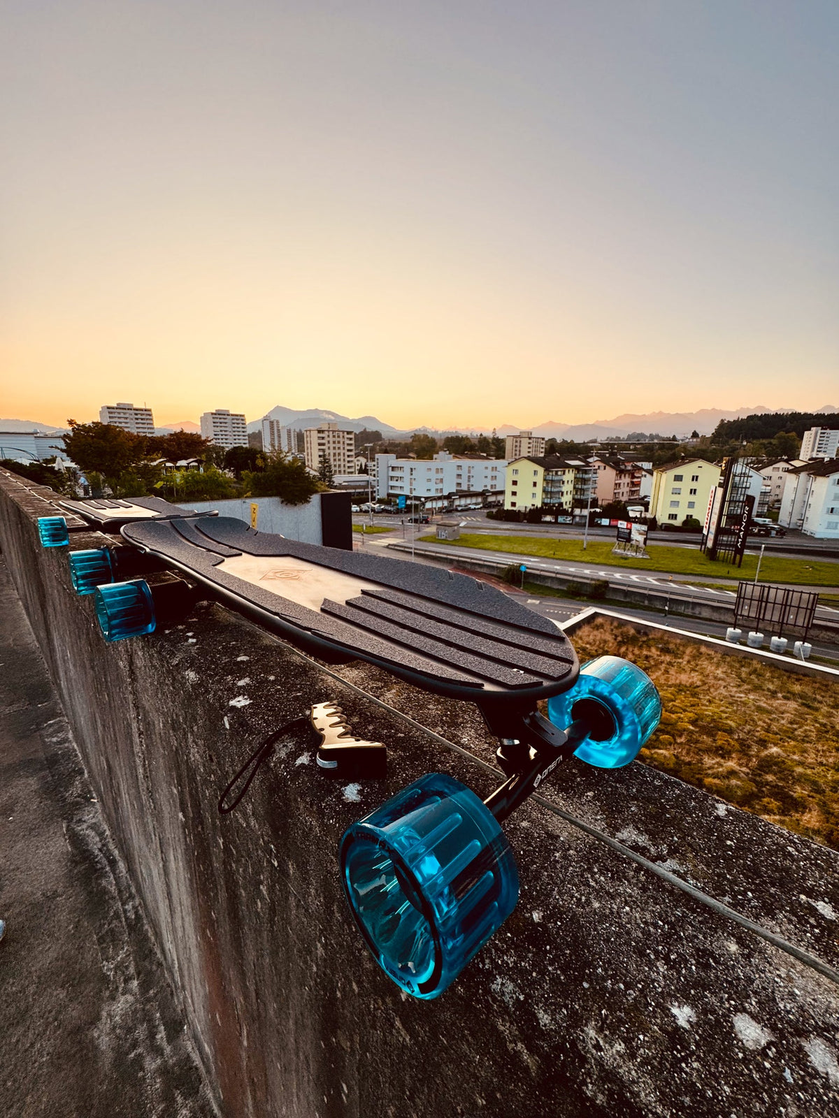 ONSRA Challenger Pro with blue wheels on a street at sunset