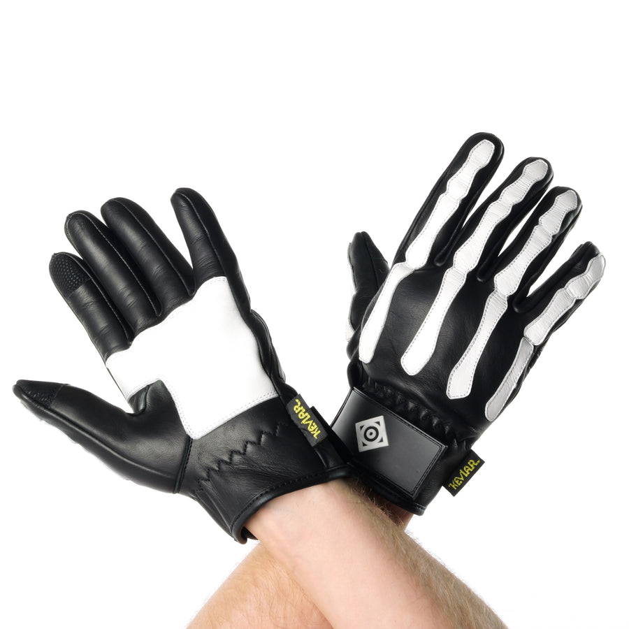 ONSRA BONES KEVLAR motorcycle gloves with white skeleton design and Kevlar reinforcement worn by a rider in a black shirt.