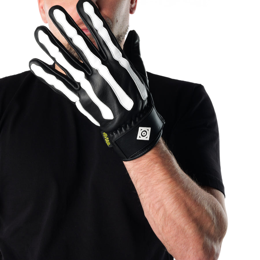 ONSRA BONES KEVLAR motorcycle gloves with white skeleton design and Kevlar reinforcement worn by a rider in a black shirt.