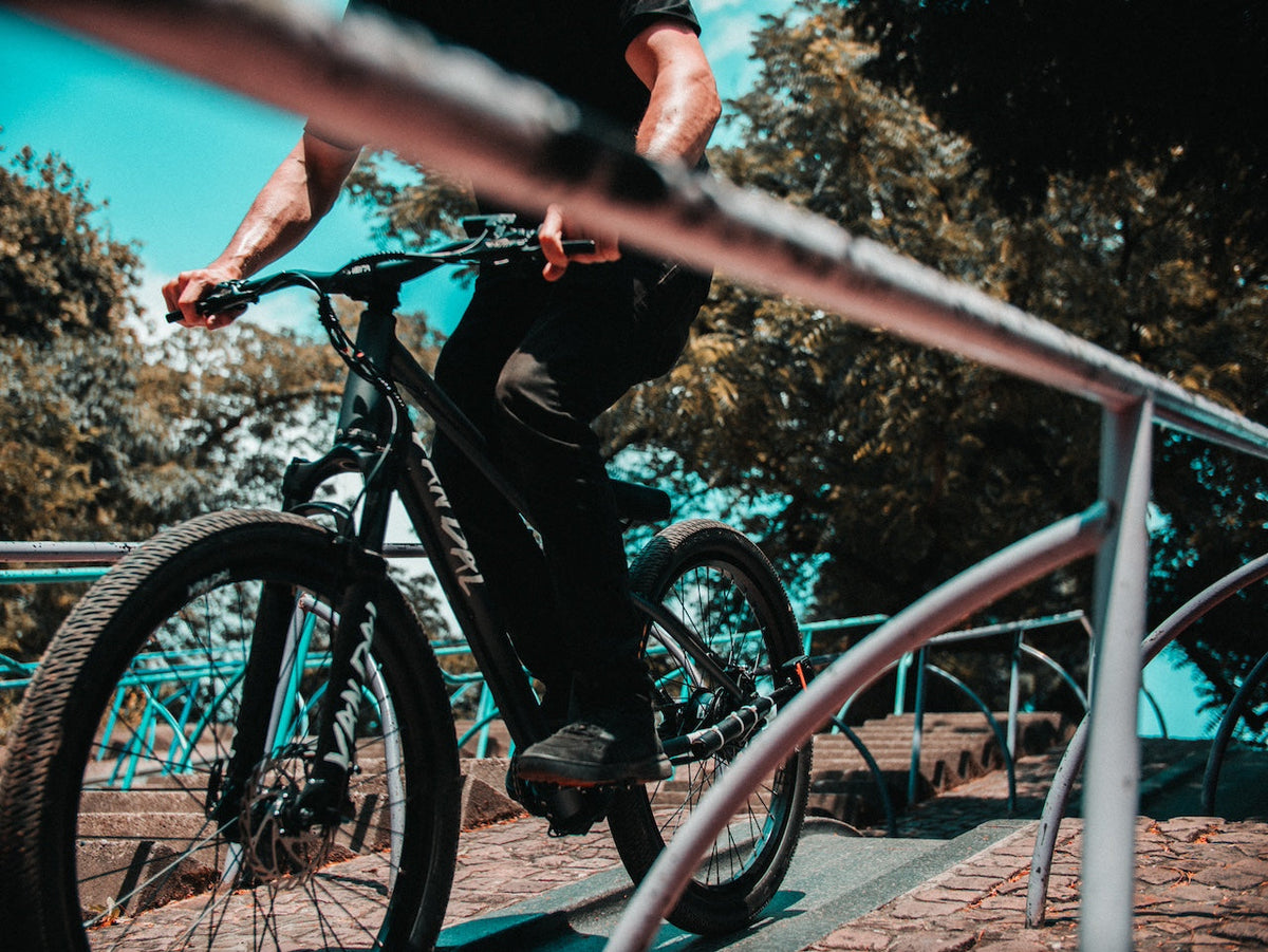 Rider on an ONSRA VANDAL electric bike along a railing
