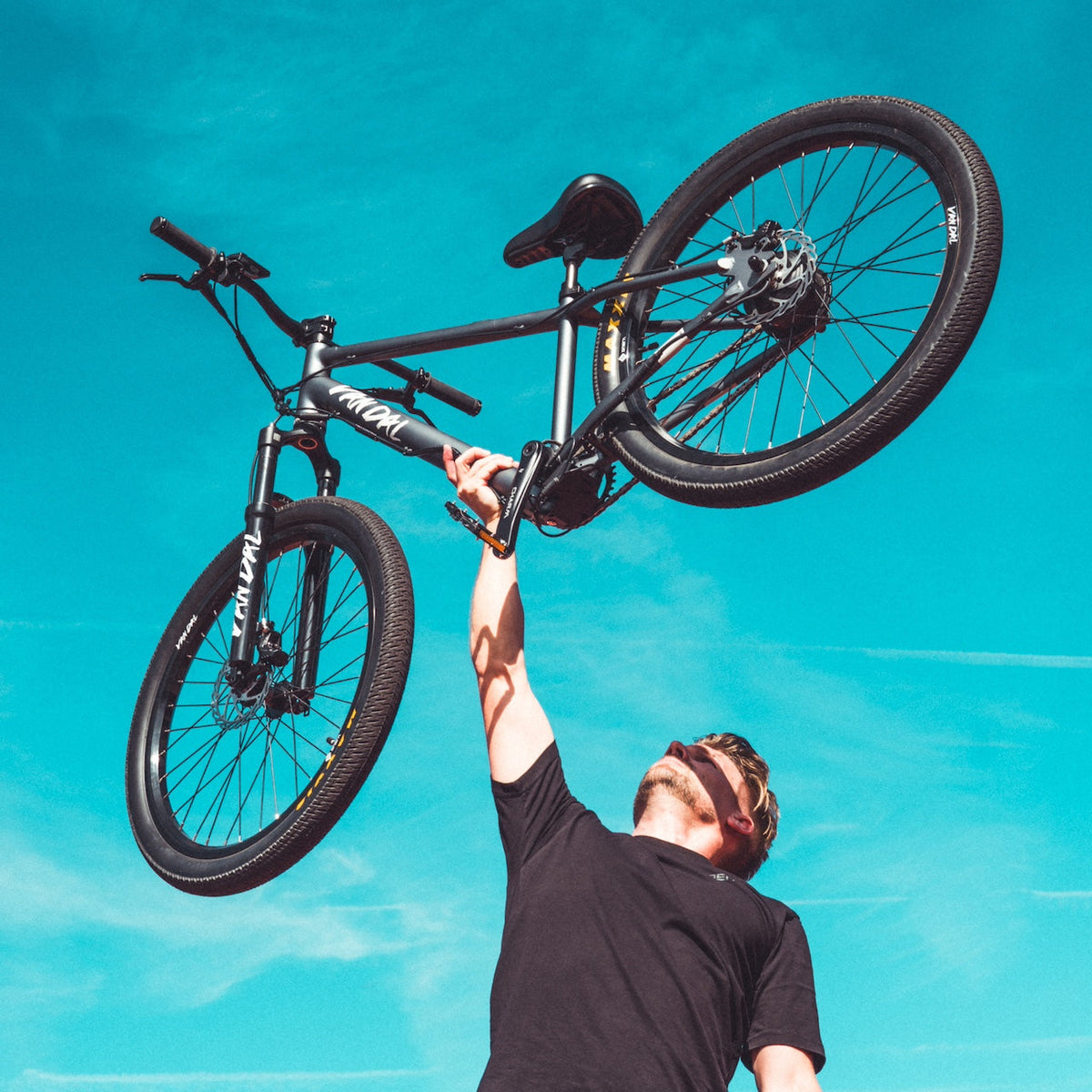 Rider lifting an ONSRA VANDAL electric bike overhead